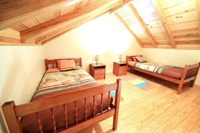 two beds in a room with wooden ceilings at Charming Studio with Sea View - Ponta do Pargo - 20 m² in Ponta do Pargo