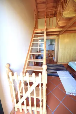 a wooden staircase in a room with a bed at Charming Studio with Sea View - Ponta do Pargo - 20 m² in Ponta do Pargo