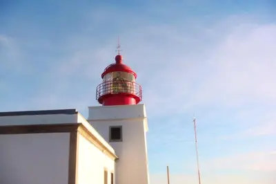 a red lighthouse on top of a white building at Charming Studio with Sea View - Ponta do Pargo - 20 m² in Ponta do Pargo