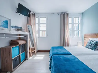 a bedroom with a bed and a tv in it at Ohana Madeira Guest House in Porto da Cruz