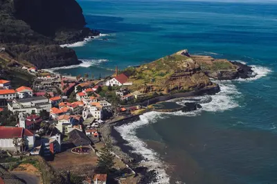 an aerial view of a small town on a hill near the ocean at Ohana Madeira Guest House in Porto da Cruz