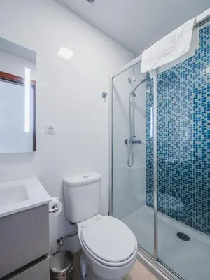 a bathroom with a toilet and a glass shower at Ohana Madeira Guest House in Porto da Cruz
