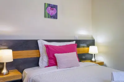 a bedroom with a bed with pink and white pillows at Vilamar- Madeira Inn Group in Calheta