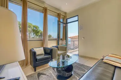 a living room with a couch and a glass table at Vilamar- Madeira Inn Group in Calheta