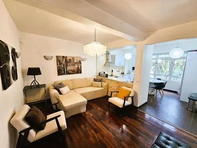a living room with a couch and chairs and a kitchen at ParadisMare in Machico