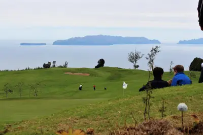 people sitting on a hill looking at a golf course at ParadisMare in Machico