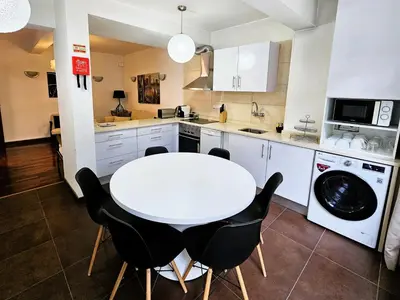 a kitchen with a white table and black chairs at ParadisMare in Machico