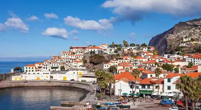 a group of houses on a hill next to the water at Atlantis Apartment in Câmara de Lobos