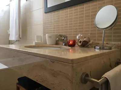a bathroom with a marble sink with a mirror at Atlantis Apartment in Câmara de Lobos