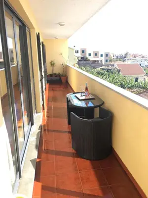 a balcony with a table and chairs on a building at Atlantis Apartment in Câmara de Lobos