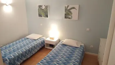 a room with two beds and a lamp in it at Apartamento VISTA MAR in Funchal
