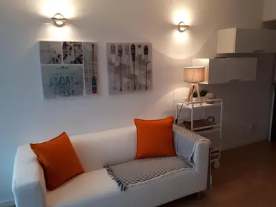 a living room with a white couch with two orange pillows at Apartamento VISTA MAR in Funchal