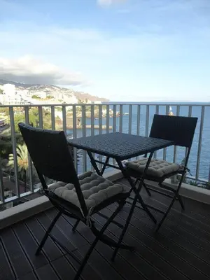 two chairs and a table on a balcony with the ocean at Apartamento VISTA MAR in Funchal