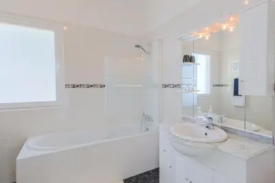 a white bathroom with a tub and a sink and a bath tub at Casa Serena Apartments in Arco da Calheta
