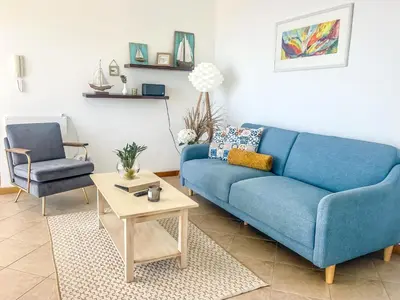 a living room with a blue couch and a table at Casa Serena Apartments in Arco da Calheta