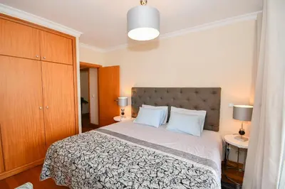 a bedroom with a bed with two blue pillows at M Palace II in Funchal
