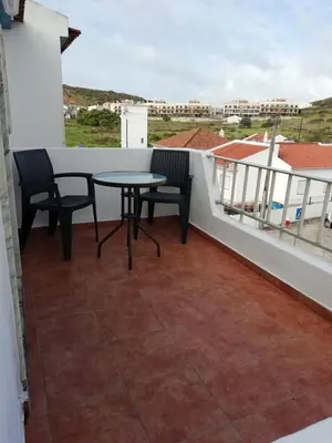 a patio with a table and chairs on a balcony at Casa Furt@do in Burgau