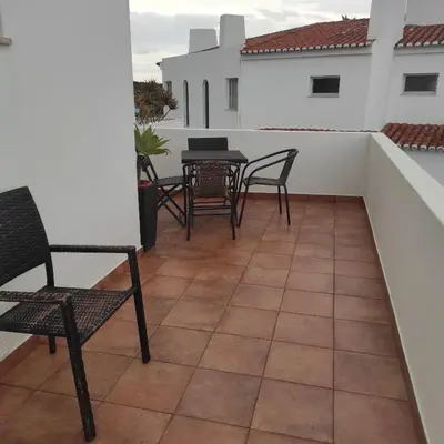 a balcony with chairs and tables on a white wall at Casa Furt@do in Burgau