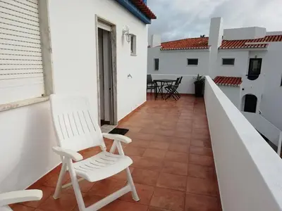 a balcony with two white chairs and a table at Casa Furt@do in Burgau