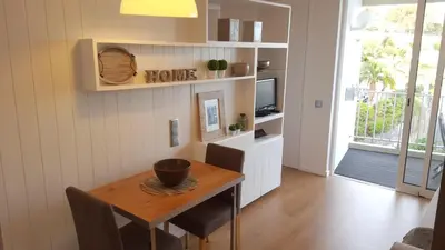 a dining room with a table and a tv at Apartamento Funchal com vista Mar in Funchal