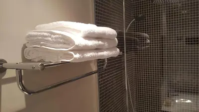 a pile of white towels on a rack in a bathroom at Apartamento Funchal com vista Mar in Funchal