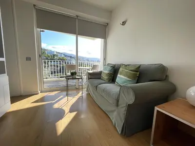 a living room with a couch and a large window at Apartamento Funchal com vista Mar in Funchal