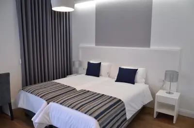 a bedroom with a large white bed with blue pillows at Edificio Charles 201 in Funchal
