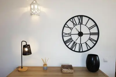 a clock on a wall above a wooden desk at Buganvilia Praia da Luz in Luz