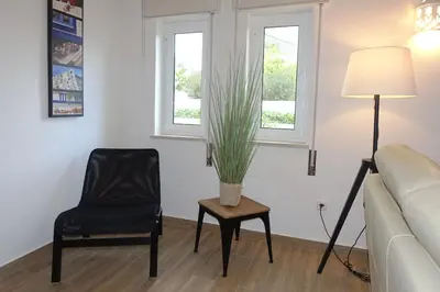 a living room with a chair and a plant on a table at Buganvilia Praia da Luz in Luz