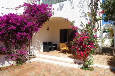 a house with purple flowers on the side of it at Buganvilia Praia da Luz in Luz