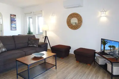 a living room with a couch and a tv at Buganvilia Praia da Luz in Luz