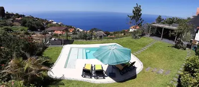 an aerial view of a house with a pool and an umbrella at Casa Velha D Fernando e Casa Avó Augusta in Ribeira Brava