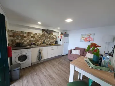 a living room with a couch and a kitchen at Casa Velha D Fernando e Casa Avó Augusta in Ribeira Brava