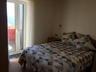 a bedroom with a bed in front of a window at Vila do Rocha in Calheta