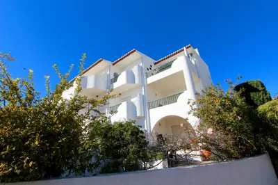 a white building with trees in front of it at CASA MONACO vue mer in Luz
