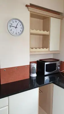 a kitchen with a clock on the wall and a microwave at CASA MONACO vue mer in Luz