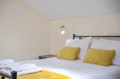 a bedroom with a white bed with yellow pillows at Eyes in the Sky in Funchal