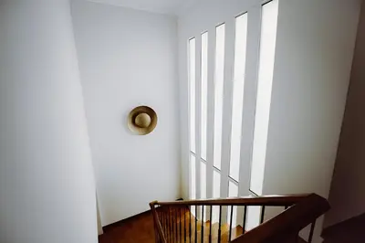 a stairway with a wooden rail and a wooden stair case at Vila Luis Mendes in Ribeira Brava