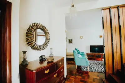 a room with a mirror and a dresser and a blue chair at Vila Luis Mendes in Ribeira Brava