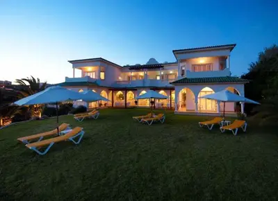 a dining room with tables and chairs and green walls at Villa Esmeralda in Lagos