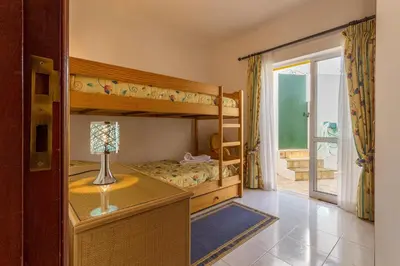 a bedroom with a bed and a table and chairs at Casa Tulipa in Luz