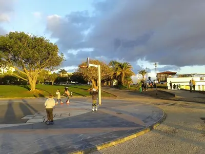 a group of people walking and skateboarding on a street at Beach Flat - Apartamento Praia Doca do Cavacas in Funchal