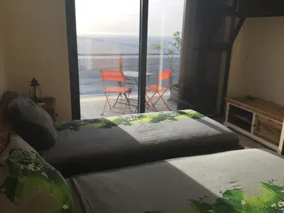a bedroom with a bed and a view of a balcony at Guesthouse-TheView in Ribeira Brava