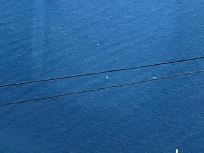a large body of blue water with power lines at Guesthouse-TheView in Ribeira Brava