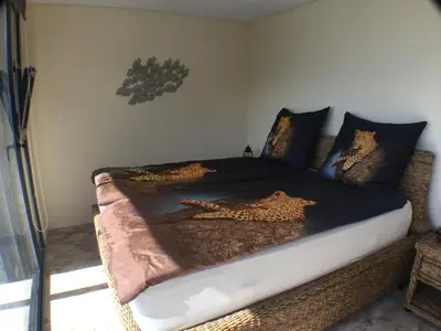 a bedroom with a bed with leopard pillows on it at Guesthouse-TheView in Ribeira Brava