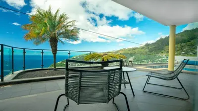 a balcony with a table and chairs and the ocean at Estrela do Mar - by LovelyStay - Lovely, Sun Filled Villa in Calheta