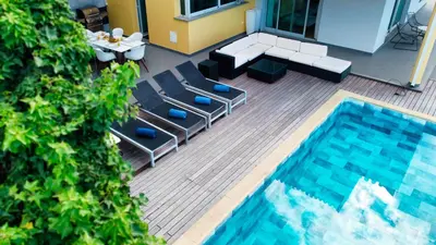 a patio with a pool and chairs and a table at Estrela do Mar - by LovelyStay - Lovely, Sun Filled Villa in Calheta