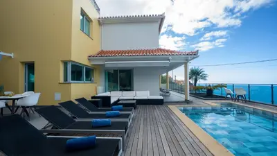 a villa with a swimming pool and a house at Estrela do Mar - by LovelyStay - Lovely, Sun Filled Villa in Calheta