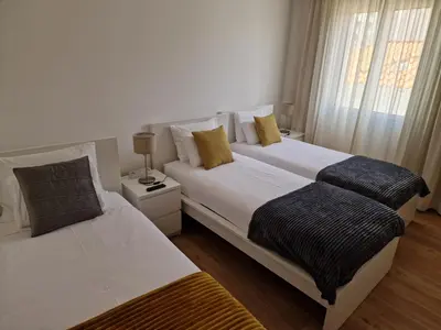 two beds in a white room with a window at Funchal Downtown Flats 2 in Funchal