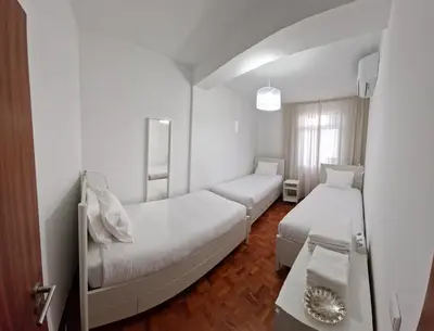 a white room with two beds and a mirror at Funchal Downtown Flats 2 in Funchal